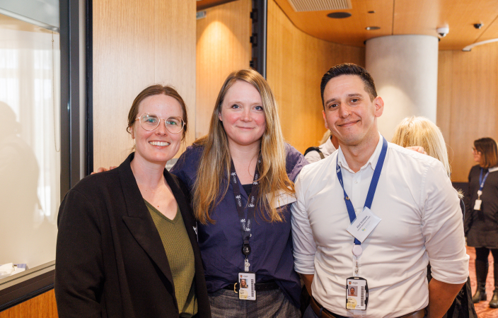 Three participants stand smiling next to each other.